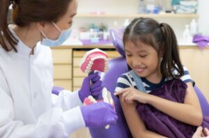 Happy young girl interacting with dental team member