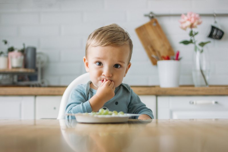 toddler attempting to eat solid food